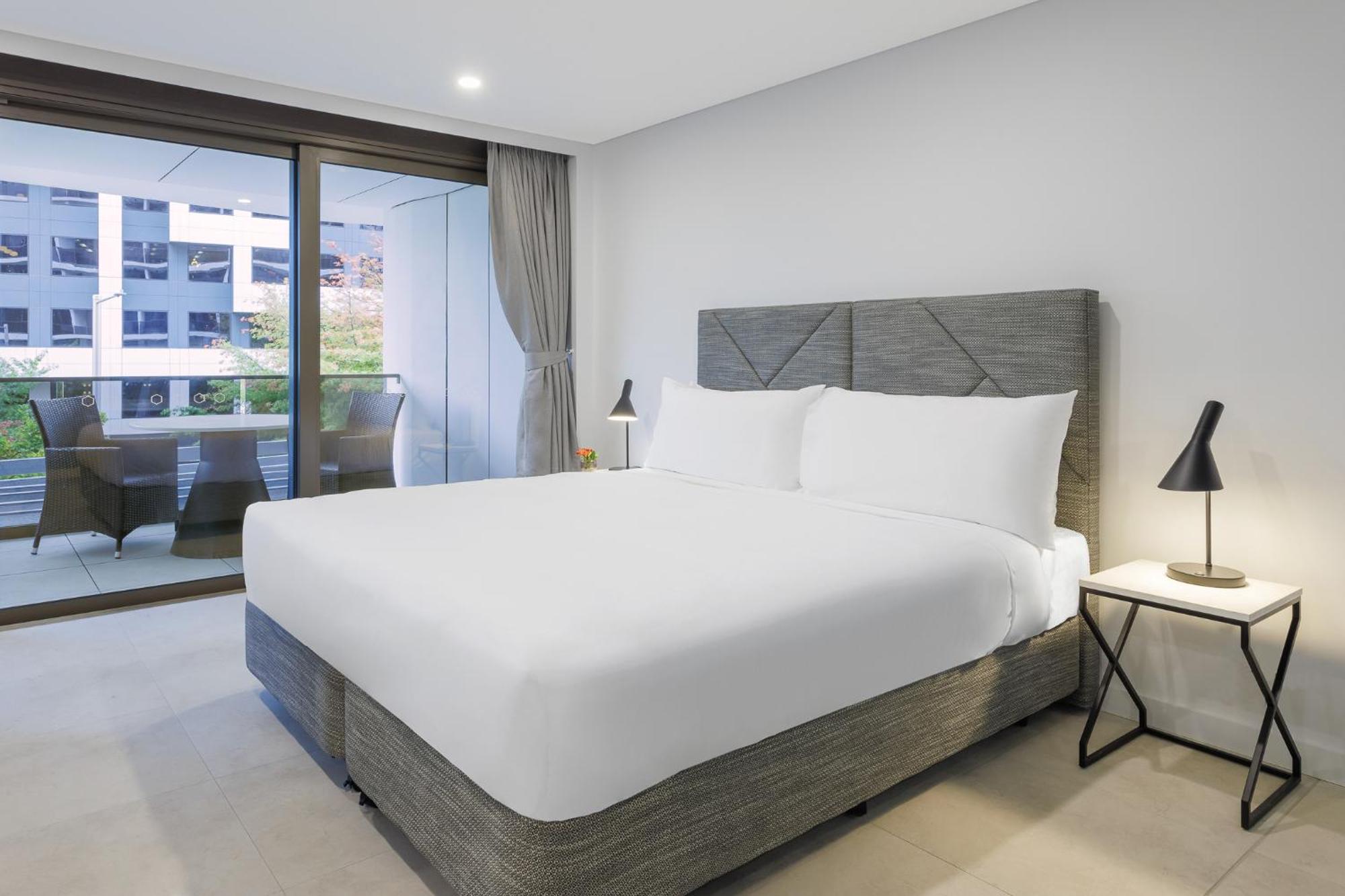 Meriton Suites Camberra Exterior foto A bed with a mattress